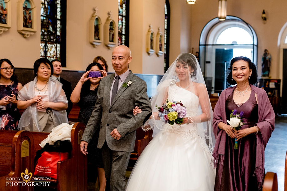 brides mom and dad walks her up the aisle at Our Lady of Guadalupe Church in the French Quarter New Orleans
