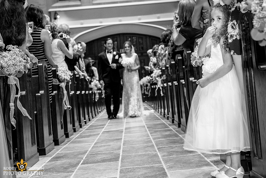 junior bridesmaid looks back at groom as bride walks in the church