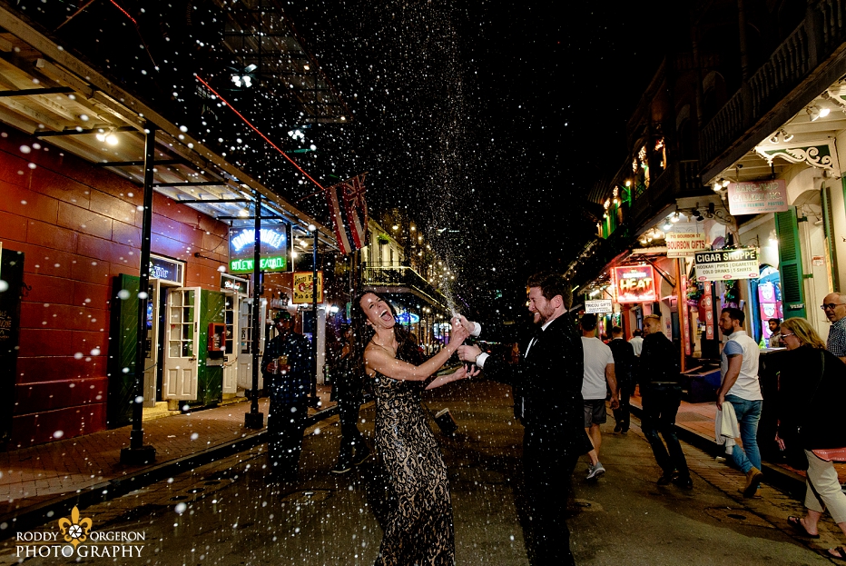 Bride and Groom Engagement Session in New Orleans on Bourbon Street popping Champagne 