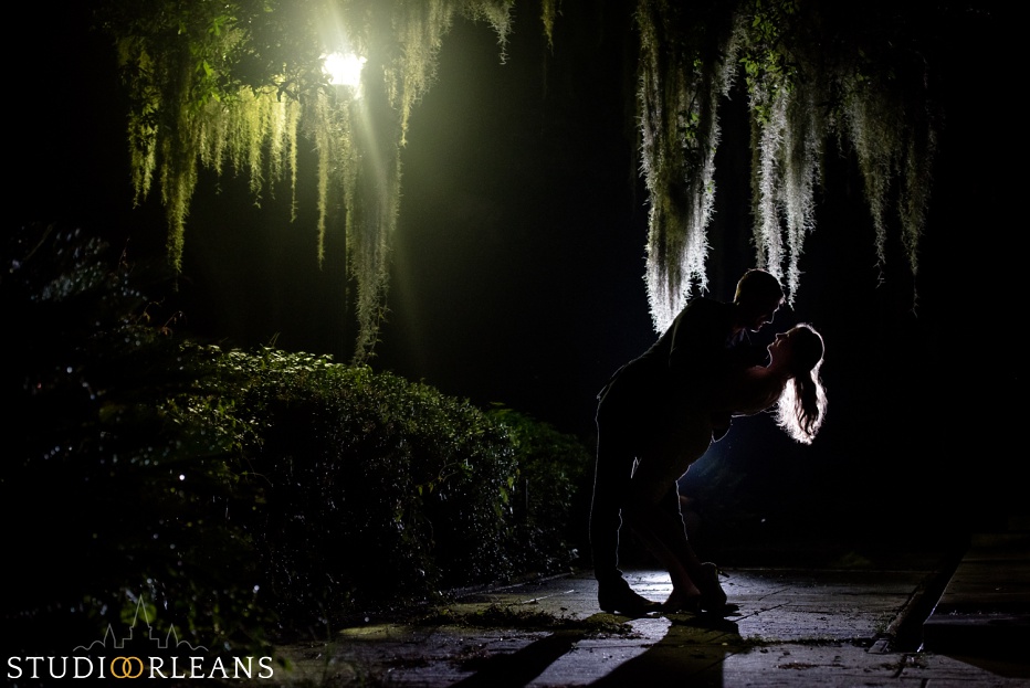 Engaged couple standing under an oak tree in Audubon Park in New Orleans