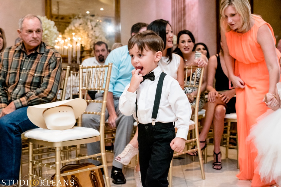 The bride and grooms son running down the aisle at the wedding ceremony at The Balcony Ballroom