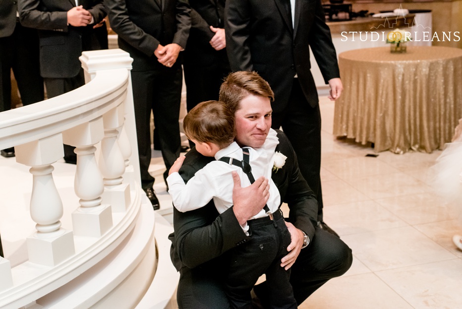 The groom hugs his son at the wedding ceremony at The Balcony Ballroom