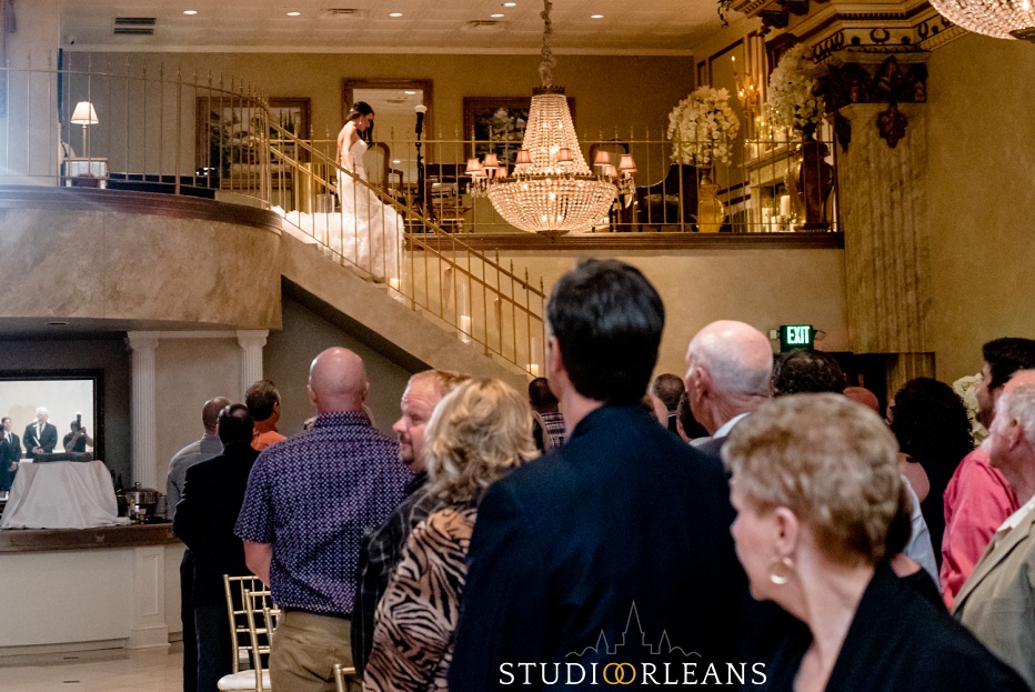 The bride walks down the stairs for her wedding ceremony at The Balcony Ballroom