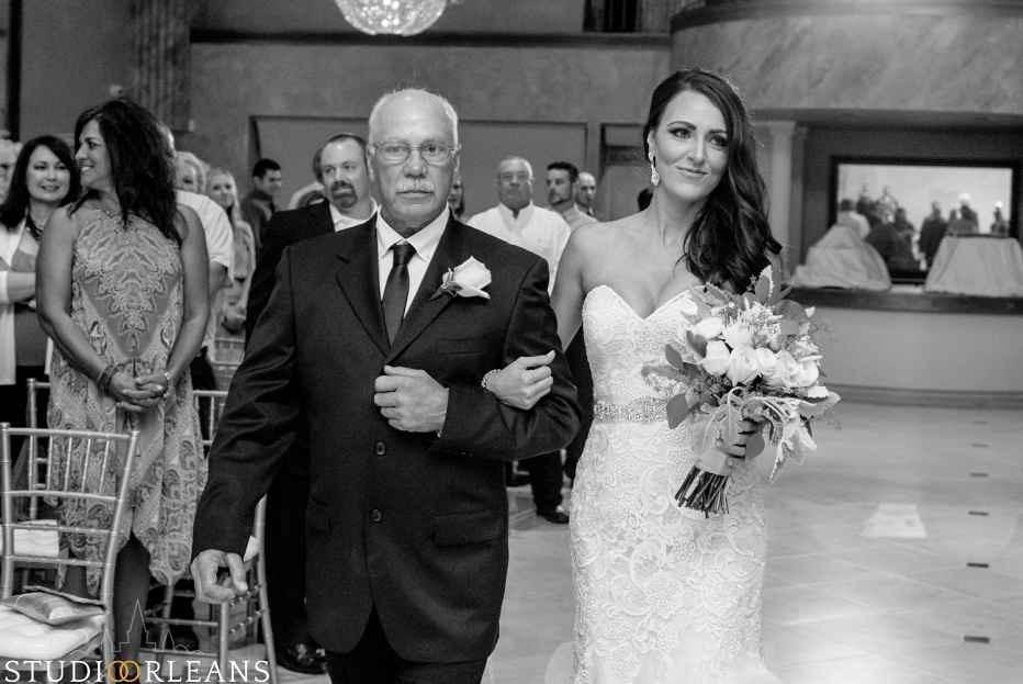 The bride and her father walk down the aisle at her wedding ceremony at The Balcony Ballroom
