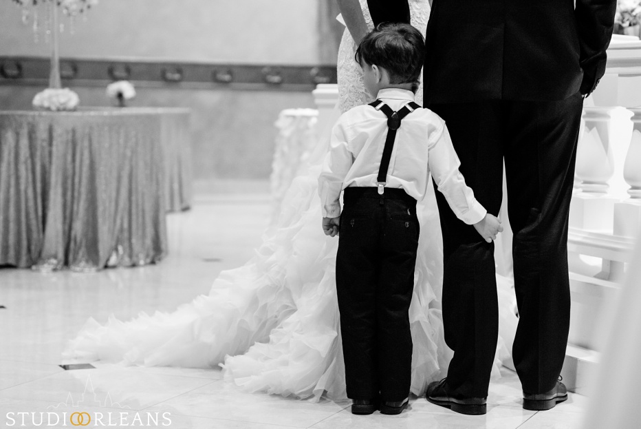 The son of the groom waits for mom to walk down the aisle at the wedding ceremony at The Balcony Ballroom