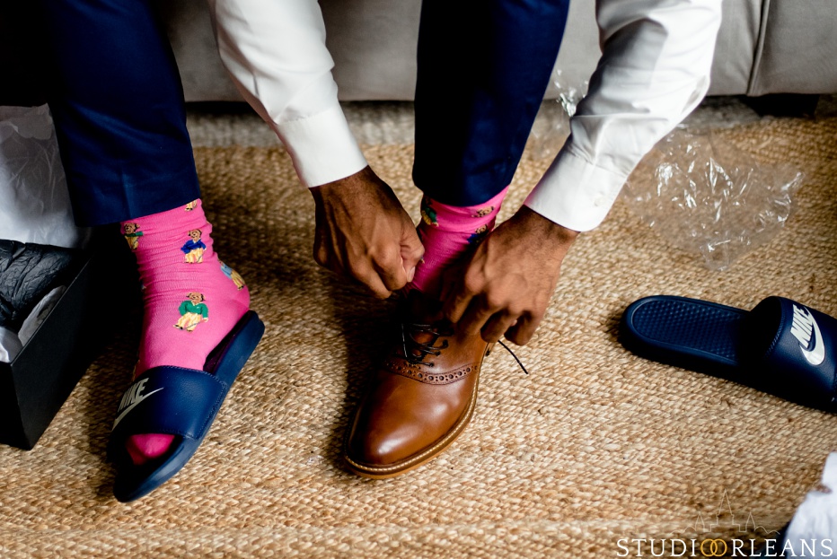 The groom putting his shoes on getting ready for the big day. Photo by Studio Orleans New Orleans Photographers
