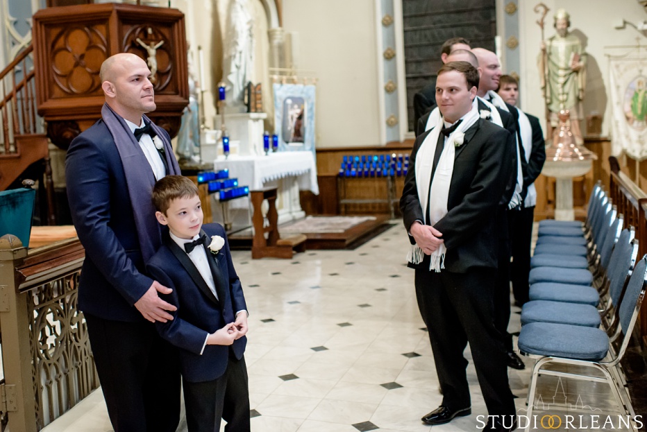 A groom and his son wait for the bride to walk into the church