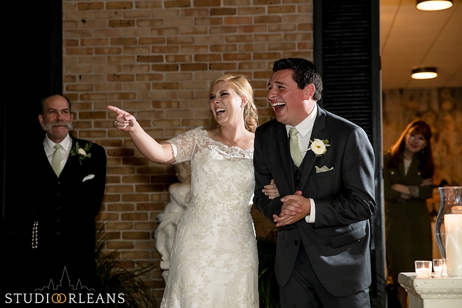 The bride and groom laugh at the best mans speech at the Chateau Lemoyne Courtyard in the French Quarter