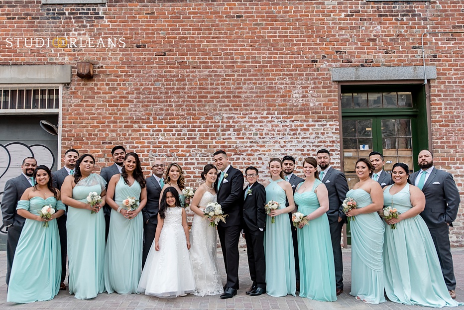 The bridal party pose for a picture against this beautiful brick wall in New Orleans