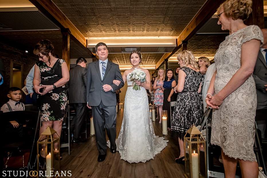 The bride and her father walk down the aisle at The Chicory Wedding venue in New Orleans