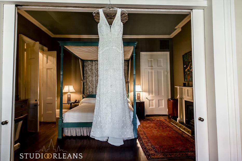 A beautiful wedding dress hangs while the bride gets ready for her elopement