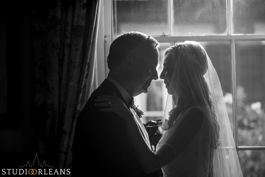 Bride and groom posing a window after there beautiful elopement in New Orleans