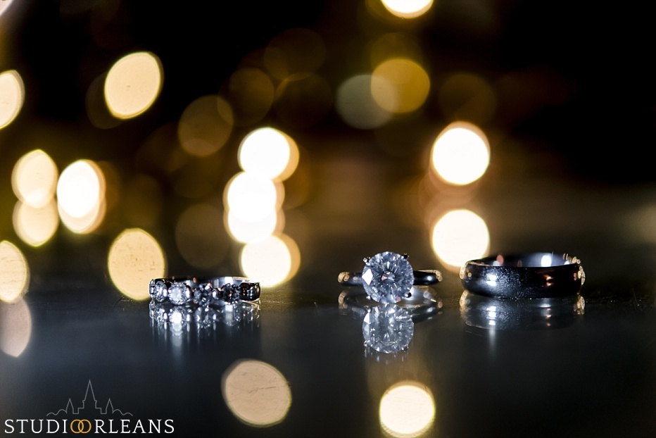 beautiful wedding rings with lights in the background