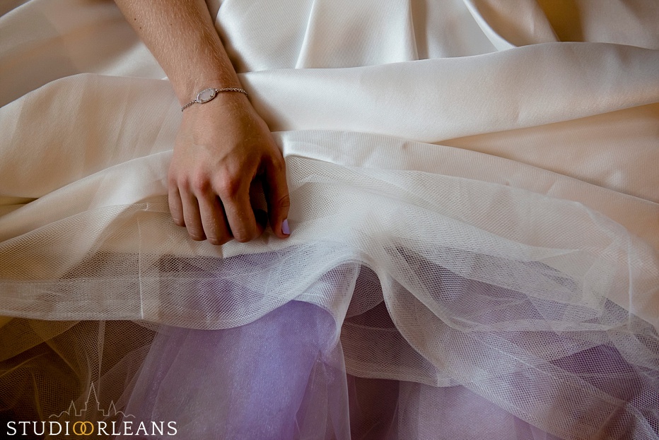 The bride sits down to relax as her mom puts her shoes on before her wedding at the House of Blues in New Orleans