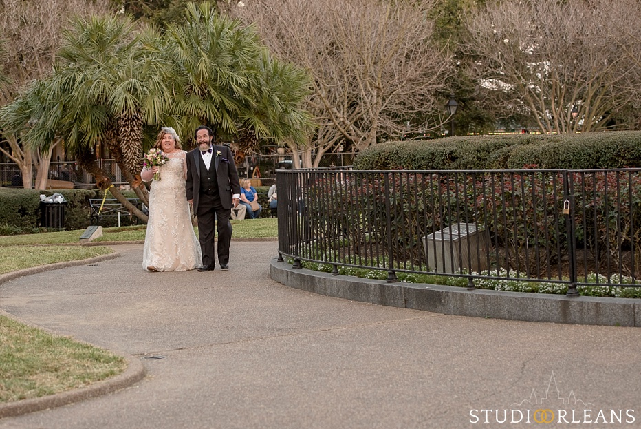 The bride and her father walking down the aisle for her wedding ceremony in Jackson Square in New Orleans