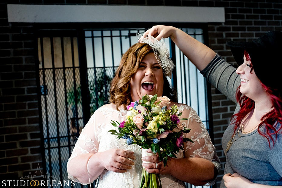 A bride laughs as her makeup artist helps her get ready
