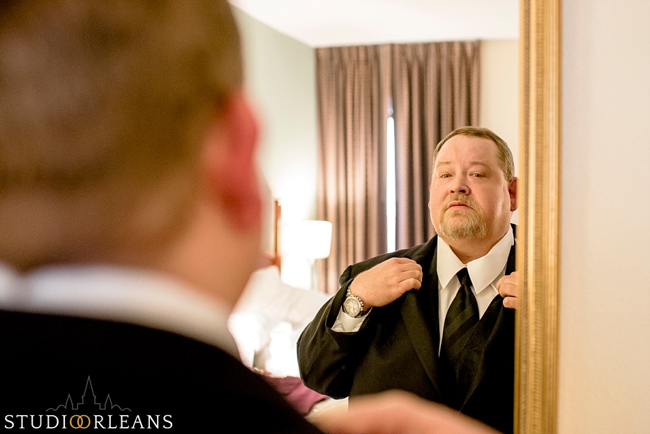 The groom gets ready fixes his jacket before the wedding