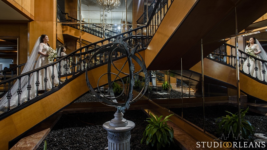 The bride looks up the staircase at the beautiful Westin Canal Place in New Orleans before her wedding at the Marigny Opera House
