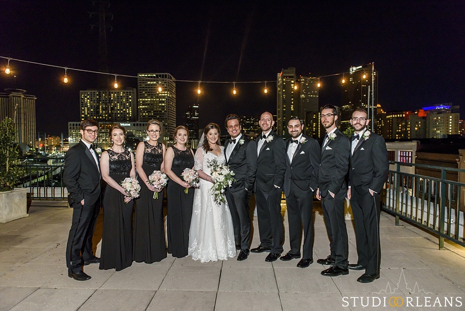 The bride, groom and bridal party pose for a picture on the rooftop at the Riverview Room