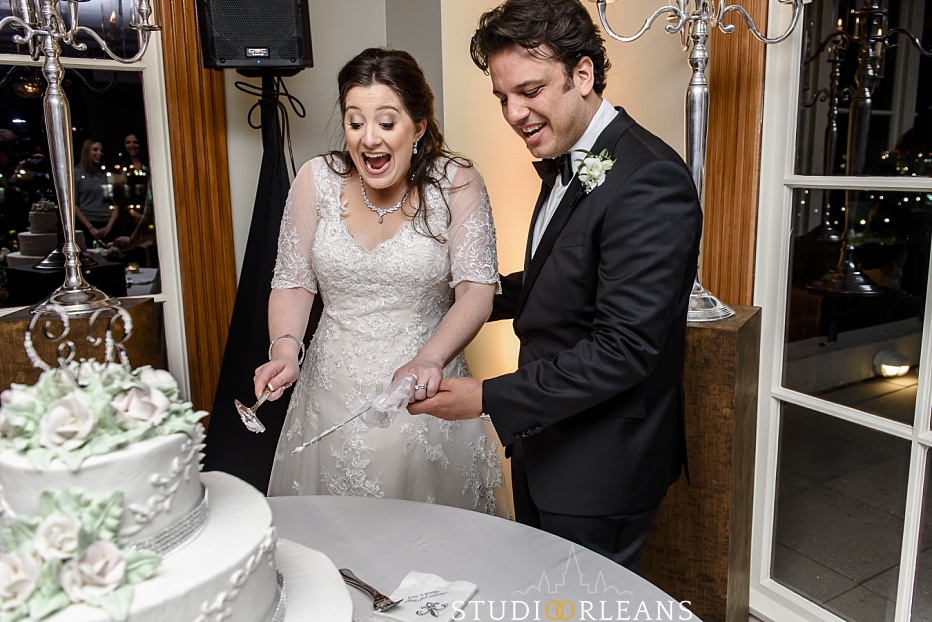 The bride and groom cut the wedding cake that was created by the Swiss Confectionery