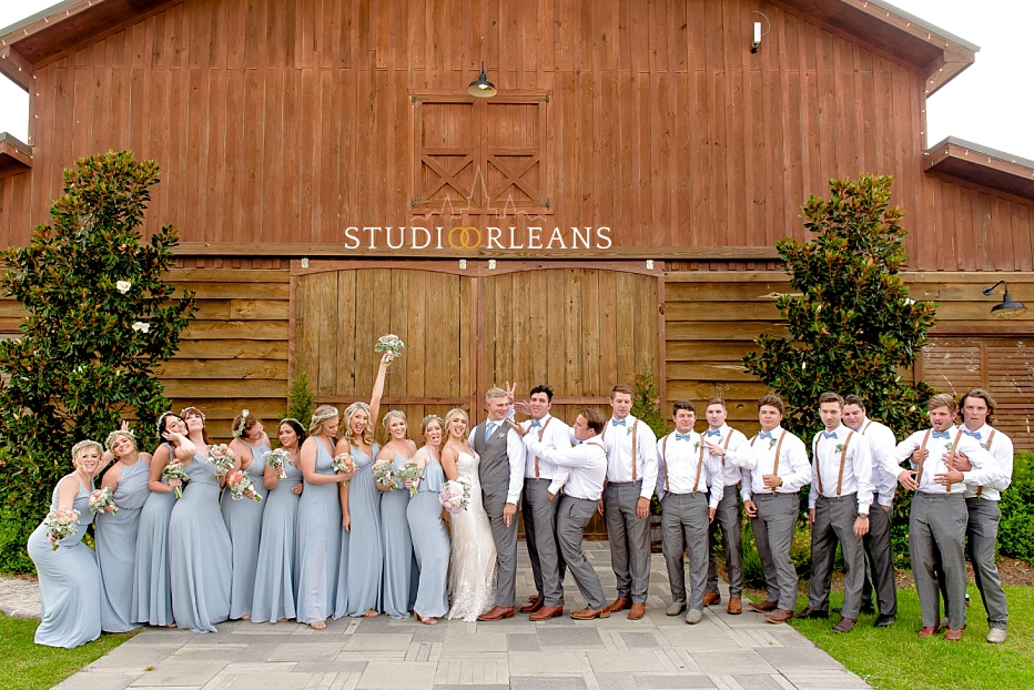 A big beautiful bridal party poses in front of the Berry Barn before the wedding ceremony