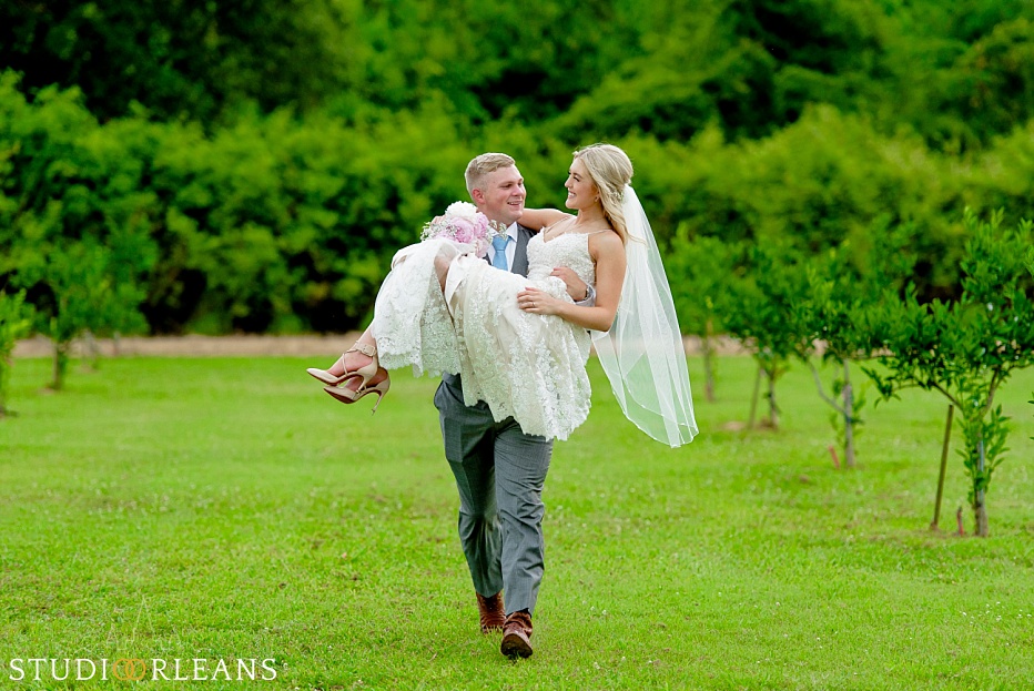 A groom carrying his bride at the Berry Barn
