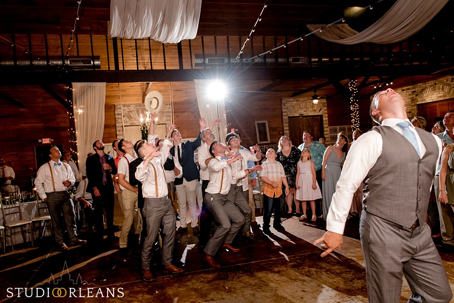 The groom throws the garter at the Berry Barn