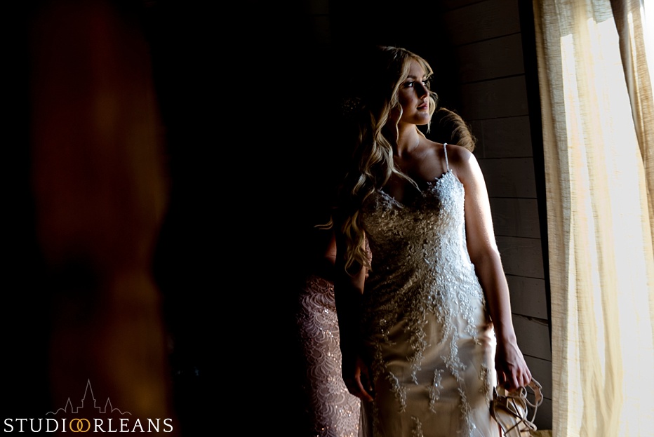 The bride looks at the window as they wrap up with some final wedding details at the Berry Barn
