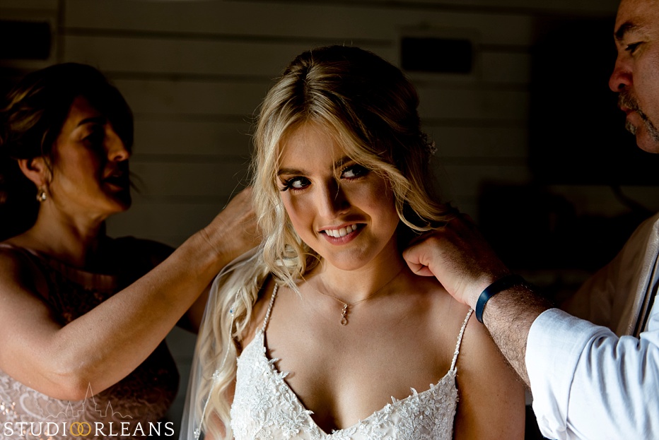 A brides mom and dad help her with finishing touches before her wedding ceremony at the Berry Barn